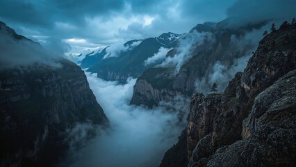 Obraz premium Mountain landscape with clouds and mist surrounding the cliffs and valley. Nature and scenery, foggy weather, and rugged terrain.