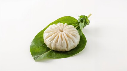 Fresh steamed bun on a green leaf, traditional Asian food, bread, steamed, snack, and healthy eating concept.