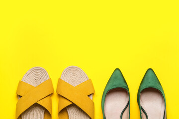Different stylish shoes on yellow background