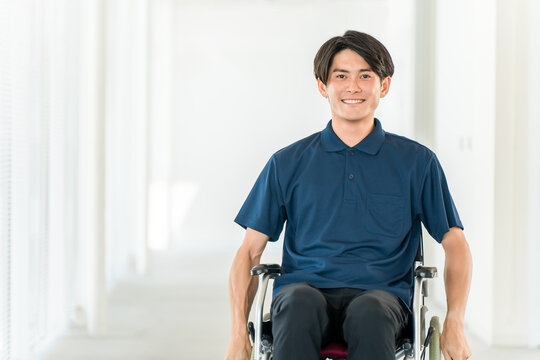 Young Asian man in a wheelchair (handicap, barrier-free, charity, care, welfare)