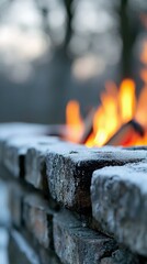 Close-up of a brick wall with ice on it, and a fire burning in the background, creating a contrast of hot and cold.