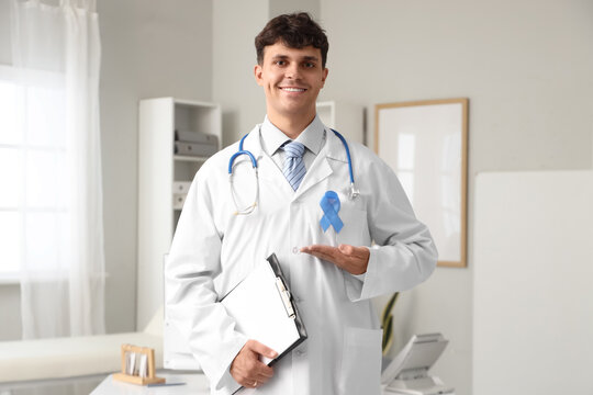 Male doctor with blue ribbon and clipboard in clinic. Prostate cancer awareness concept