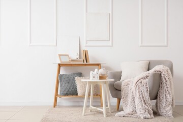 Light interior of living room with armchair, tables and cup of hot chocolate
