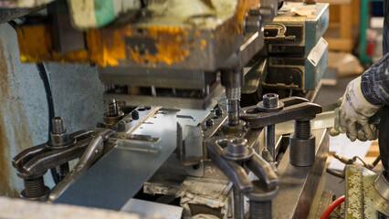 Metal Press Machine in Operation with Worker Handling Sheet Metal