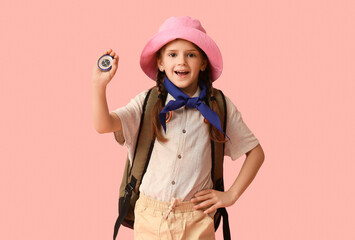 Little girl scout with backpack and compass on pink background. World Scout Day © Pixel-Shot