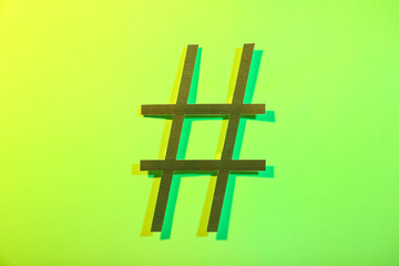 Hashtag made of paper on green background
