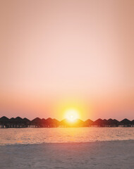 Fototapeta premium Sunset scene at Maldives beach, luxury water lodges. Travel destinations