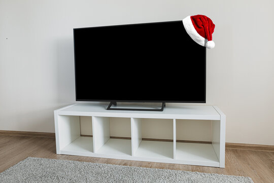 Santa Claus Hat on Lcd tv on white shef at modern room interior. Christmas and New Year celebration