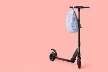 Modern electric scooter with backpack on pink background