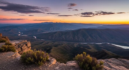 Stunning sunset panorama over winding river valley and distant mountains, a tranquil scene perfect for travel and outdoor adventure promotions