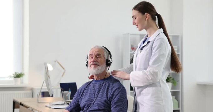 Hearing test. Doctor adjusting patient's audiometric headphones in clinic