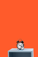 Alarm clocks on table against orange background