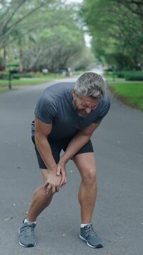 Man runner has knee pain. Knee joint dislocation after running. Sport injury. Arthritis. Man massage knee at pain point. Running injury outdoor. Knee pain during workout. Painful trauma