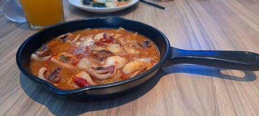 stir-fried squid with sweet and sour sauce in a pan