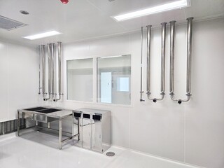 Cleanroom interior with stainless steel equipment and white walls.