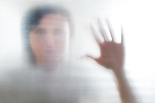 Diffused silhouette of female hands, view with shadow through plastic