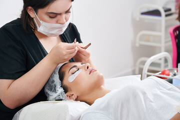 Eyelash Extension Procedure. Woman Eye with Long Eyelashes