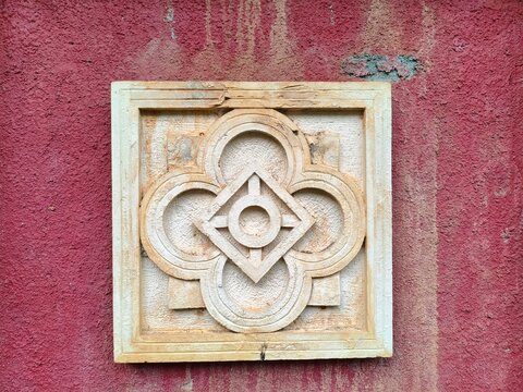 geometric stone relief on red wall 