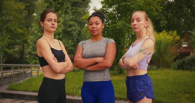 Women in sportswear smile posing with arms crossed for shots