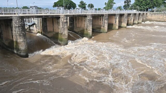 Spillway of Chiang Rai dam open for release water. Spillway, passage for surplus water over or around a dam when the reservoir itself is full.
