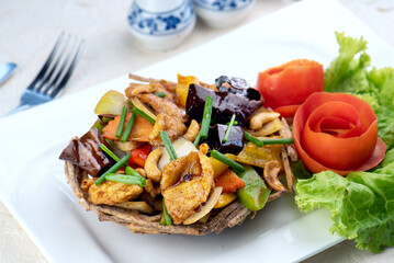 A plate of food with chicken, vegetables, and cashews.