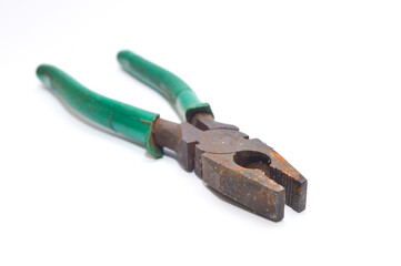 Old, rusty combination pliers (utility tool) with bright green rubber handles. Vintage work equipment in used and weathered condition. Maintenance, hardware, and construction concept. Isolated on whit