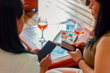 Friends ignoring each other using smartphones during gathering