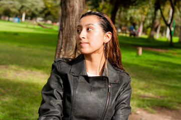 Young woman enjoying park, contemplating nature, sunlit portrait