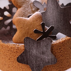 Delicious chocolate tart decorated with star and leaf cookies, walnuts, and cape gooseberries on a marble background. Perfect for holiday dessert, bakery presentation, or festive food photography