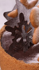 Delicious chocolate tart decorated with star and leaf cookies, walnuts, and cape gooseberries on a marble background. Perfect for holiday dessert, bakery presentation, or festive food photography