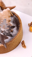 Delicious chocolate tart decorated with star and leaf cookies, walnuts, and cape gooseberries on a marble background. Perfect for holiday dessert, bakery presentation, or festive food photography