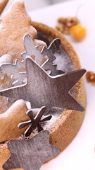 Delicious chocolate tart decorated with star and leaf cookies, walnuts, and cape gooseberries on a marble background. Perfect for holiday dessert, bakery presentation, or festive food photography