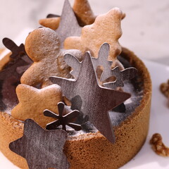 Delicious chocolate tart decorated with star and leaf cookies, walnuts, and cape gooseberries on a marble background. Perfect for holiday dessert, bakery presentation, or festive food photography