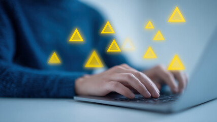 Cybersecurity warning alert laptop hands typing triangle glow technology risk pulses across laptop as hands type, yellow triangle alert float, modern security concept under threat, cautious mood