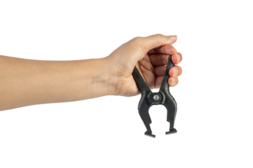 A studio shot of a black plastic spring clamp in hand isolated on a transparent background