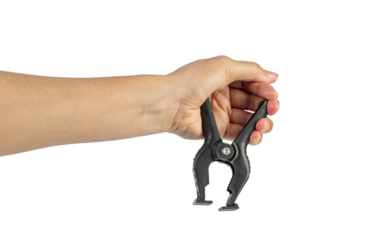 A studio shot of a black plastic spring clamp in hand isolated on a transparent background