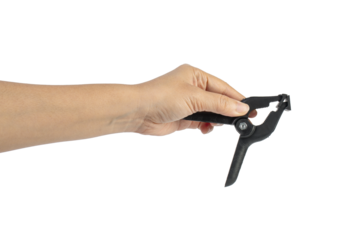 A studio shot of a black plastic spring clamp in hand isolated on a transparent background