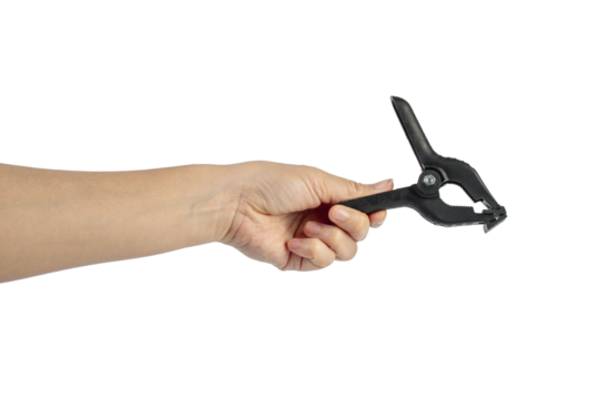 A studio shot of a black plastic spring clamp in hand isolated on a transparent background