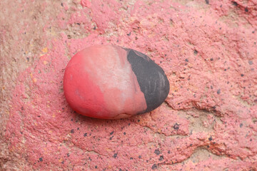 Stone with paint pink and black background