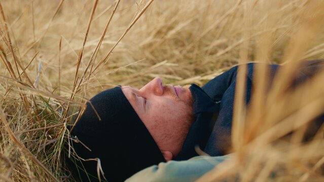 A Person Relaxing in Nature, Surrounded by Tall Grass Under a Clear Sky, Capturing the Essence of Peace and Serenity While Enjoying the Outdoors in a Tranquil Environment