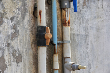 old Pipes on wall with valve for water supply  

