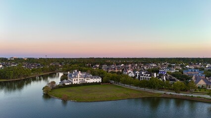 Aerial view of large mansion houses in affluent neighborhood by Woodlands lake, Houston, Texas, expensive suburban homes surrounding by lush green trees, USA