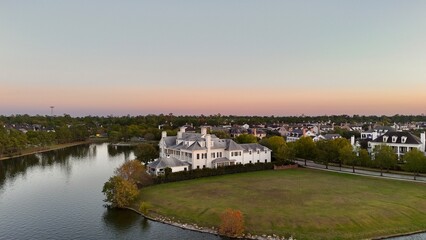 Aerial view of large mansion houses in affluent neighborhood by Woodlands lake, Houston, Texas, expensive suburban homes surrounding by lush green trees, USA