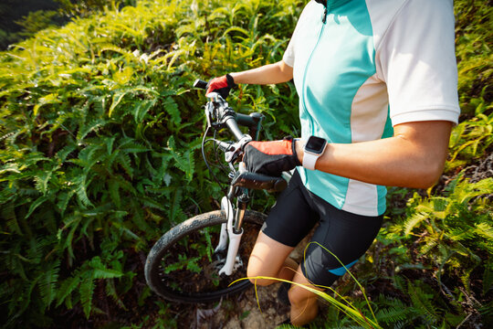 Cross country biking woman cyclist riding mountain bike on tropical forest trail