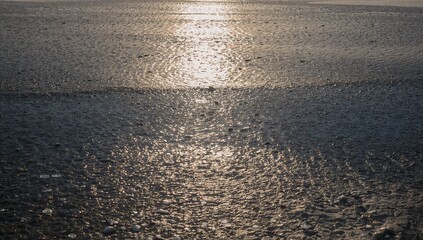 Abstract Light Reflection on Damp, Textured Ground at Sunset