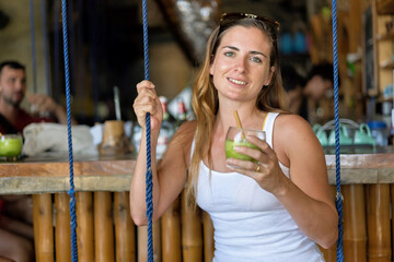 Solo female traveler enjoying a refreshing drink in El Nido, Philippines