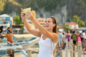 Woman taking a selfie in El Nido, Philippines, enjoying a sunny vacation