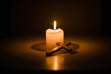 Quiet meditation featuring glowing candle and simple wooden cross, perfect for conveying peace, faith, remembrance and hope in spiritual contexts