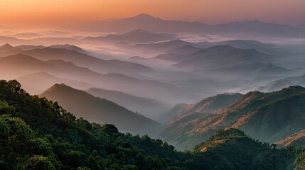 Breathtaking mountain range at dawn with misty valleys and lush green forests, perfect for travel blogs, nature documentaries, and inspirational marketing campaigns