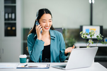 Happy asian business woman have the joy of talking on the smartphone, tablet and laptop video call on the modern office